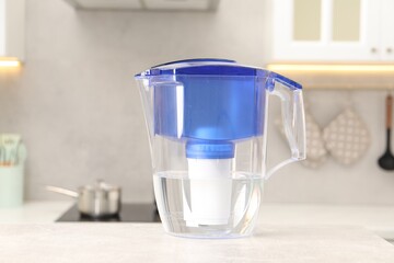 Water filter jug on light grey table in kitchen