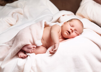 A newborn baby peacefully sleeping on a soft white blanket