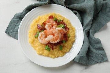 Plate with fresh tasty shrimps, bacon, grits and green onion on white marble table, top view