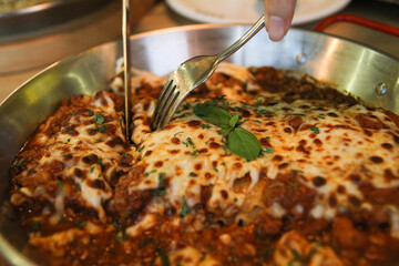 
Bolognese pasta sliced ​​with a fork and knife