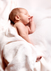 A newborn baby peacefully sleeping on a soft white blanket
