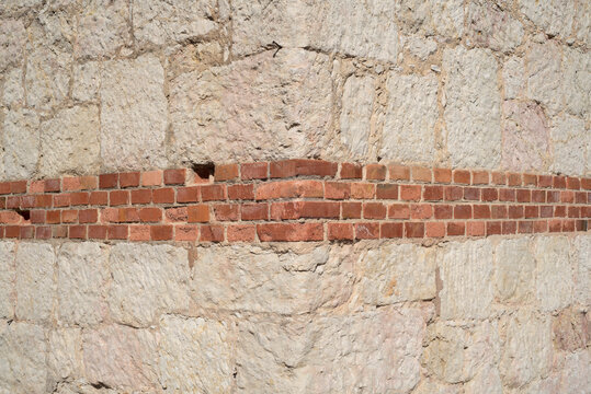 Esquina con fila de ladrillos en pared de losetas de piedra