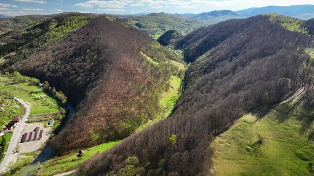 Rolling landscapes and woodlands in the spring.Footage from valley of  Slătioara River, tributary of Iza River with hilly terrain and forests in spring within Maramureș region of Carpathian Mountains.