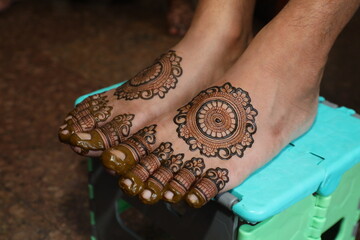 Bangalore, India 9th April 2024: Indian Groom wedding henna mehendi mehndi feet close up. Henna...
