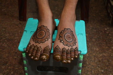 Bangalore, India 9th April 2024: Indian Groom wedding henna mehendi mehndi feet close up. Henna...