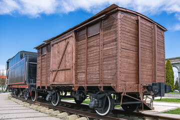 Obraz premium An old wooden two-axle boxcar. A type of railway two-axle covered freight car. The design of the wagon provides for the possibility of rapid conversion for the transportation of people and animals.