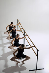 Practicing plie. Top view on for teen girls, elegant ballet dancers in black costumes training at...