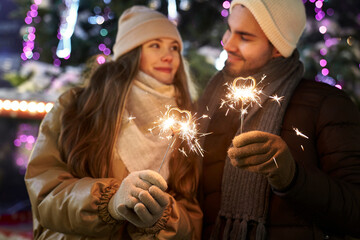 Caucasian couple with sparklers during New Years's party outdoors
