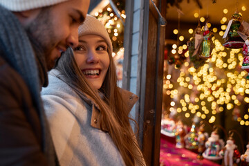 Caucasian couple having fun on Christmas market retail
