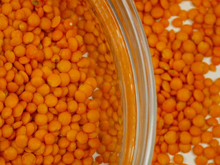 Glass  bowl  with red lentil stands on a white table