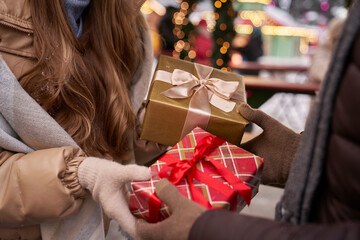 Caucasian couple exchanging presents on Christmas market