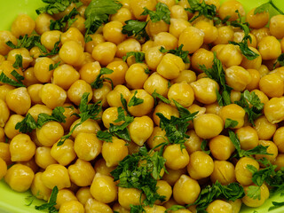 Fresh boiled chick-peas sprinkling with fresh parsley, background