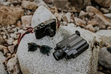 Hipster starter kit, analog cameras and vintage sunglasses on a rock
