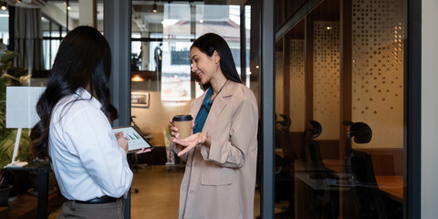 Obraz premium Business team Asian woman working using digital tablet tech discussing financial market data standing at corporate office meeting