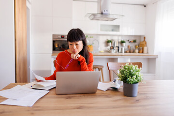 Woman working remotely from home doing paperwork