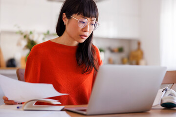 Woman doing paperwork while working remotely from home