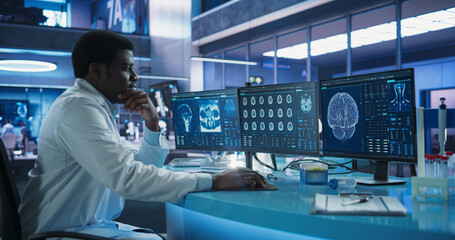 Cancer Research Center Medical Laboratory: Black Male Neuroscientist Using Desktop Computer To...