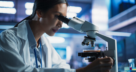 Medical Development Laboratory: Close-Up Portrait of Asian Female Scientist Using Microscope,...
