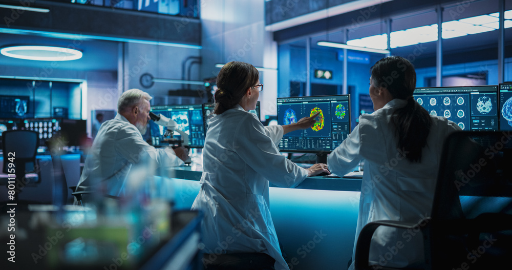 Poster Back View Of Diverse Scientists Working In Medical Research Center. Male Doctor Using Microscope And His Female Colleagues Looking At MRI Brain Scans On Desktop Computers. Biotechnology Lab Concept.