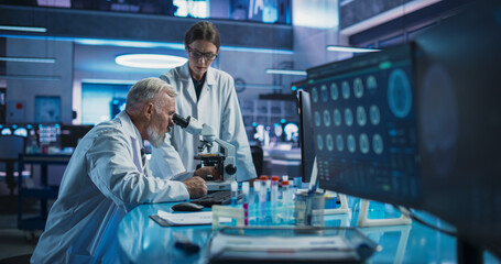 Caucasian Male Neuroscientist Using Microscope to Analyze Petri Dish Sample And Talking To Female...