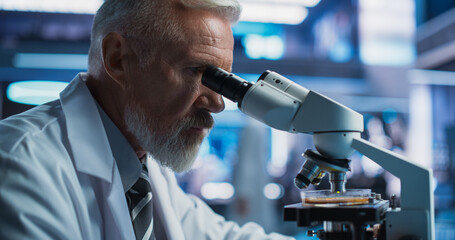 Medical Development Laboratory: Close Up Of Senior Caucasian Male Scientist Using Microscope,...