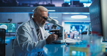 Medical Development Laboratory: Senior Caucasian Male Scientist Using Microscope, Analyzes Petri...
