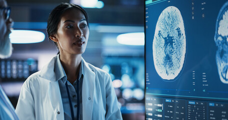 Neuroscience Laboratory Meeting: Close-Up Female Asian Scientist And Male Surgeon Discussing MRI...