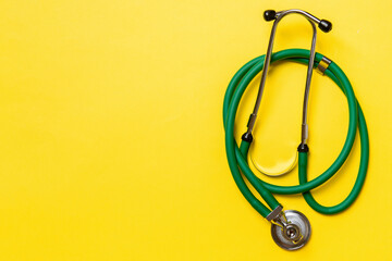 Top view of green medical stethoscope on colorful background with copy space. Medicine equipment...