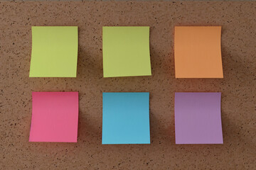 assorted colorful sticky notes on cork background in a neat layout