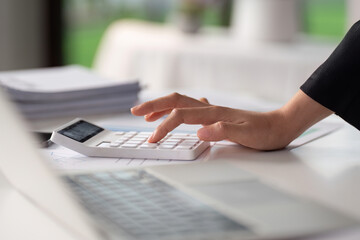 Businesswoman working with document and using calculator for checking finance report