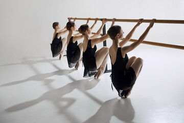Discipline and determination. Tender teen girls, ballet dancers in black costumes attending dance...