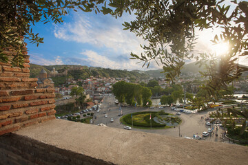 Beautiful panoramic landscape of old city in Tbilisi on the background of blue cloudy sky and green...