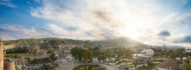 Landscape panorama of historical Tbilisi street with mountains and blue cloudy sunny sky on the background - obrazy, fototapety, plakaty