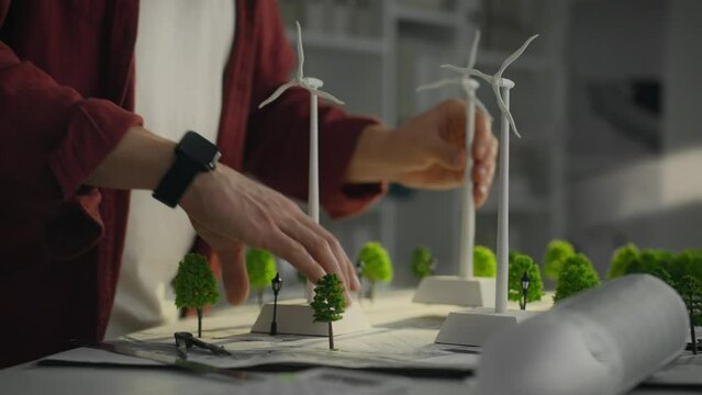 A Caucasian man who is actively involved in research into green energy using models of windmills. His work aims to create sustainable urban environments based on the use of alternative energy sources