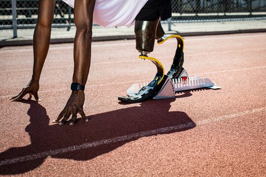Paralympic sprinter with prosthetic legs started racing from a starting block - Powered by Adobe
