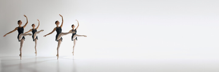 Four ballet dancers, teen girls in black leotards dancing against grey studio background. Synchronization. Ballet, art, dance studio, classical style, youth concept. Banner. Empty space to insert text - Powered by Adobe
