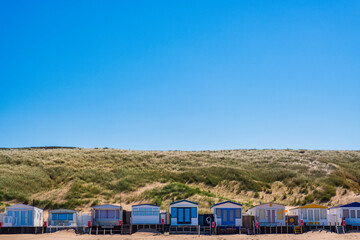 Small cozy beach cottages in front of the dunes on the beach of Egmond aan Zee - Netherlands