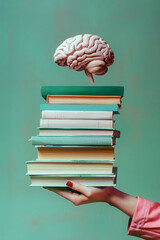 Human brain and books on green background. Education and learning concept.