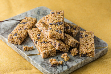 Various granola bars on table background. Cereal granola bars. Superfood breakfast bars with oats, nuts and berries, close up.