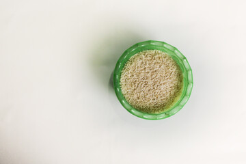 photography of rice in a plastic container on an isolated white background