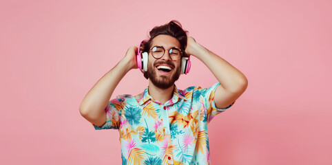 Portrait of happy modern young man listening to music with headphones on colorful background