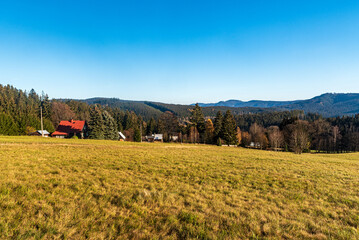 Meadow with buildings and hills on the backgeound bellow Lysa hora hill in Moravskoslezske Beskydy...