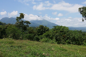 Weide, Urwald und Vulkan Arenal in Wolken bei La Fortuna in Costa Rica