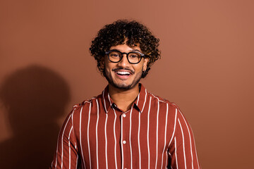 Portrait of nice young man toothy smile wear striped shirt isolated on brown color background