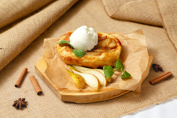 Pear pie with ice cream on a wooden board