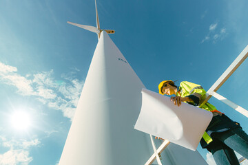 female engineer working outdoor with safety at wind turbines clean energy power station background, worker people with renewable energy technology for future concept. - 801166335