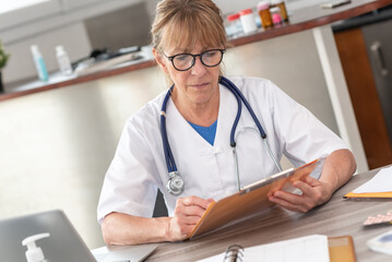 Female doctor reading a clinical record