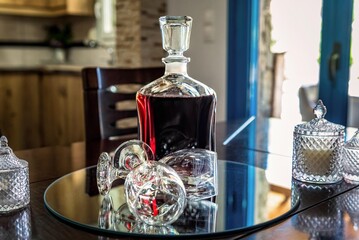 Close-up view of a sleek carafe filled with rich red wine, accompanied by two elegant wine glasses. Ideal for illustrating concepts related to wine culture, fine dining, celebrations, and relaxation.
