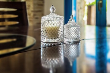 Close-up view of two exquisite glass vases, each serving as a sophisticated candle holder. Used as centerpieces for weddings, events, or home decor. Atmosphere with their beauty and charm