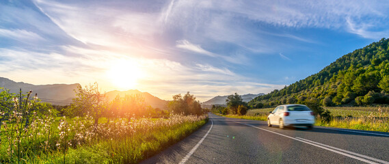 rental car in spain mountain landscape road at sunset - obrazy, fototapety, plakaty